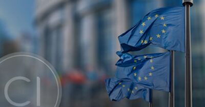Flags of the European Union waving outside an official building, symbolizing the legal routes to EU citizenship in 2026.